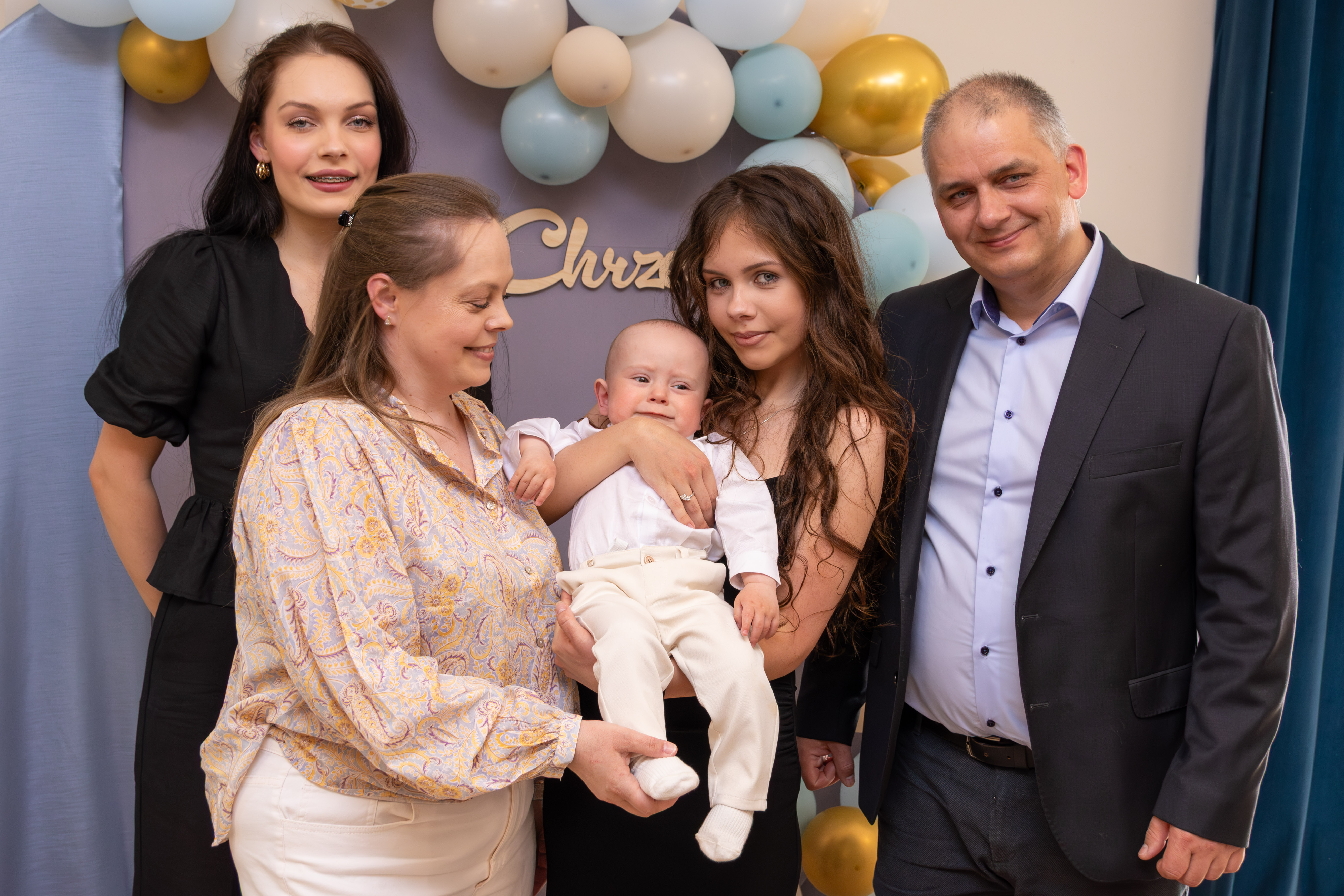 rodzina czteroosobowa pozuje z dzieckiem