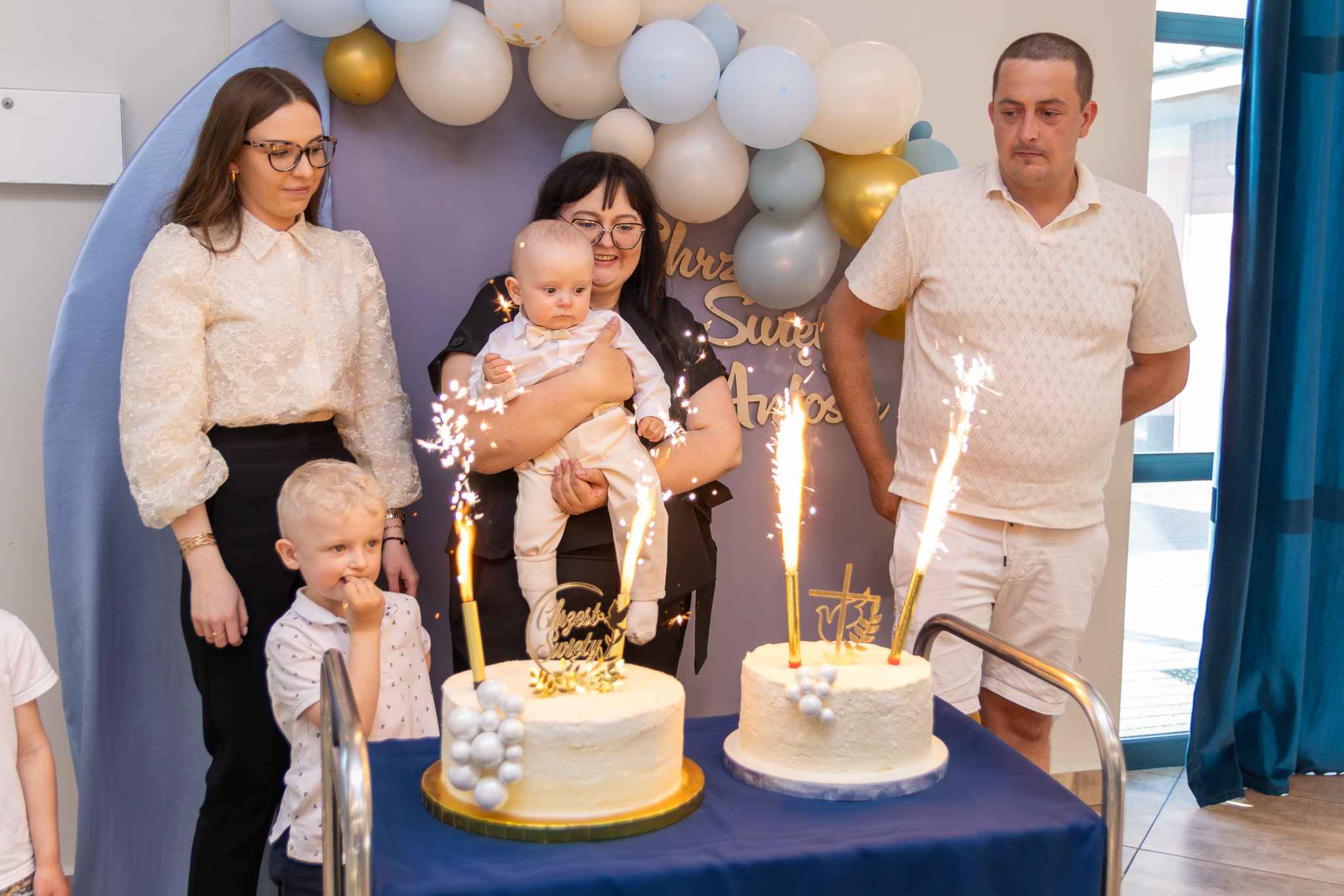 mama, chrzestni, brat i ochrzczony przy torcie