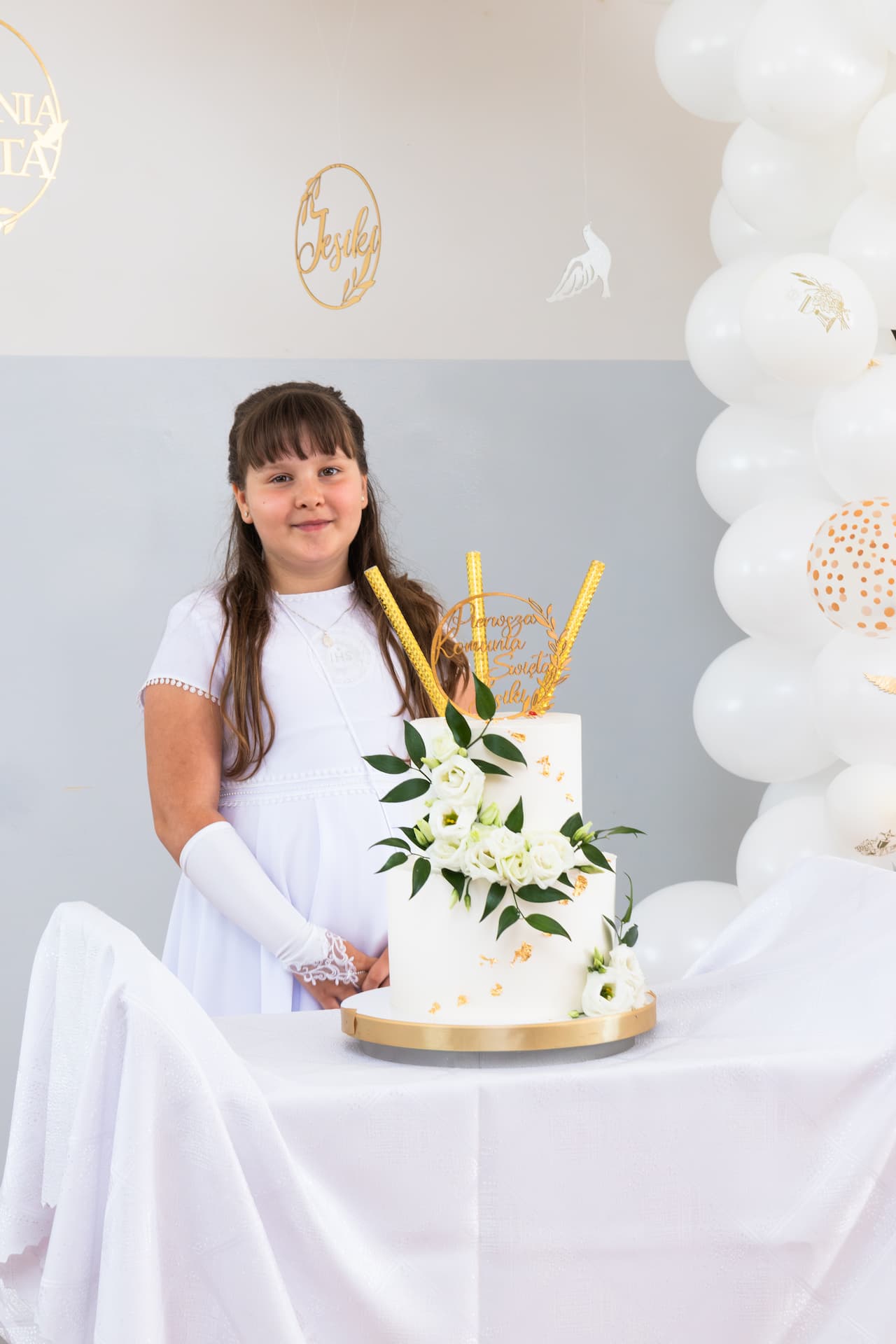 Portret dziewczynki w sukience komunijnej przy torcie
